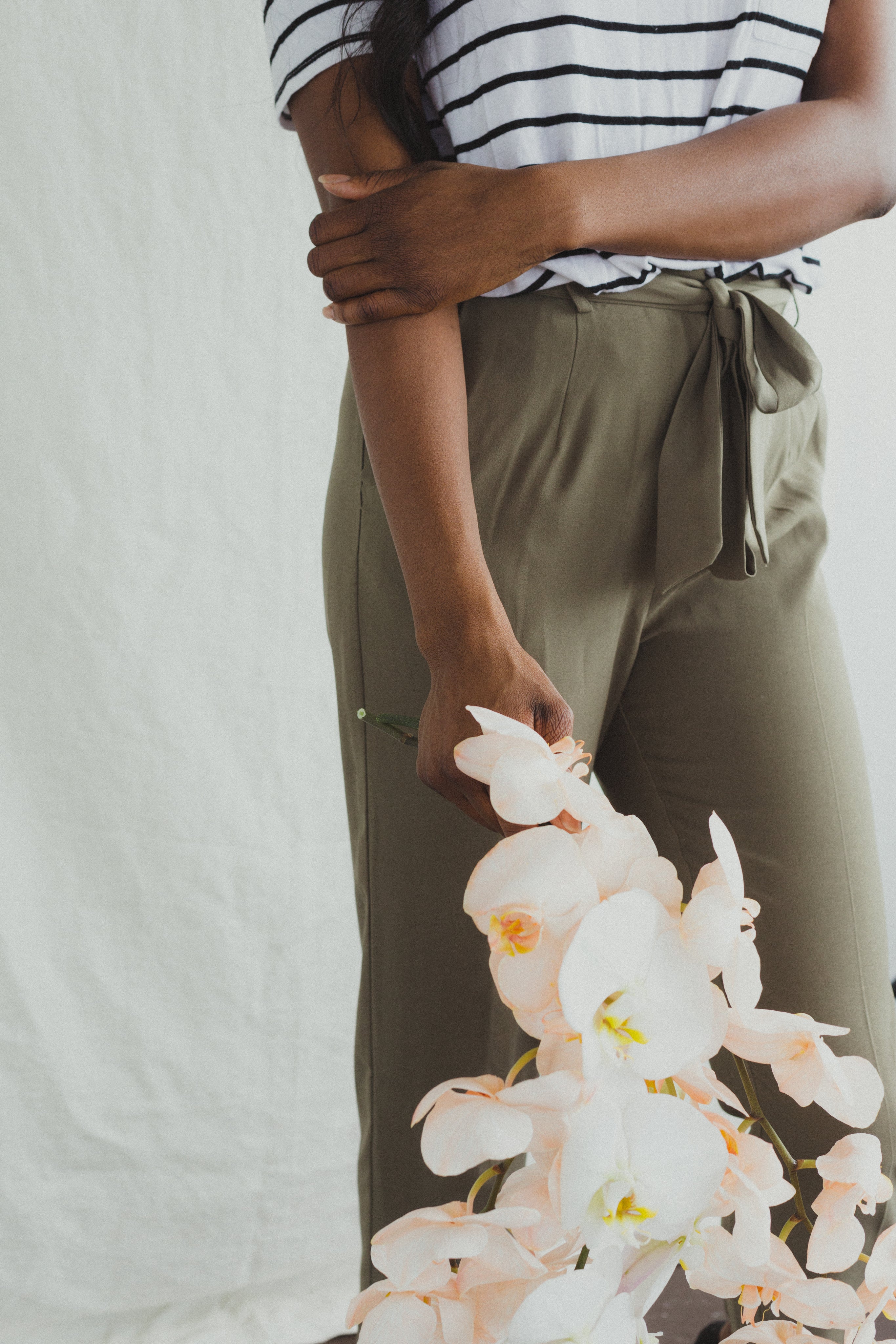 a-model-in-khakis-holding-orchids.jpg